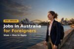 Jobs in Australia for foreigners — smiling worker in front of the Sydney Opera House and harbour skyline